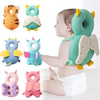 Baby wearing a green owl-shaped head support with various animal-themed pillows displayed around.