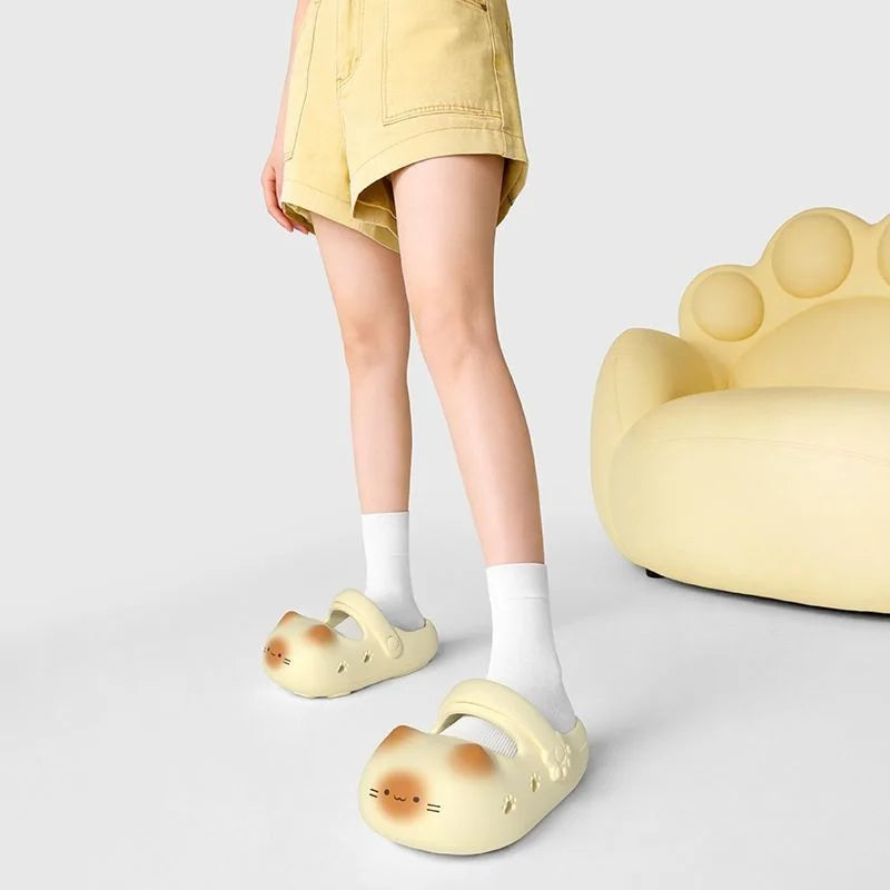 Person wearing yellow bear-shaped clogs with a matching chair on a light gray background