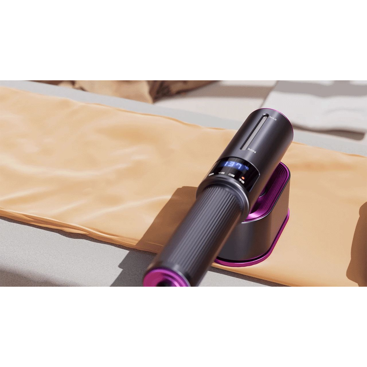 A close-up of a black handheld vacuum cleaner with purple accents resting on its matching charging dock, placed on a beige fabric surface.