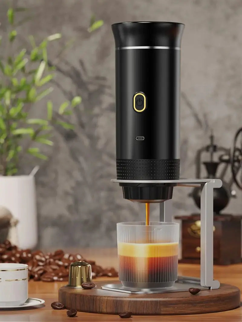 Black coffee maker pouring coffee into a glass on a wooden surface with a blurred background