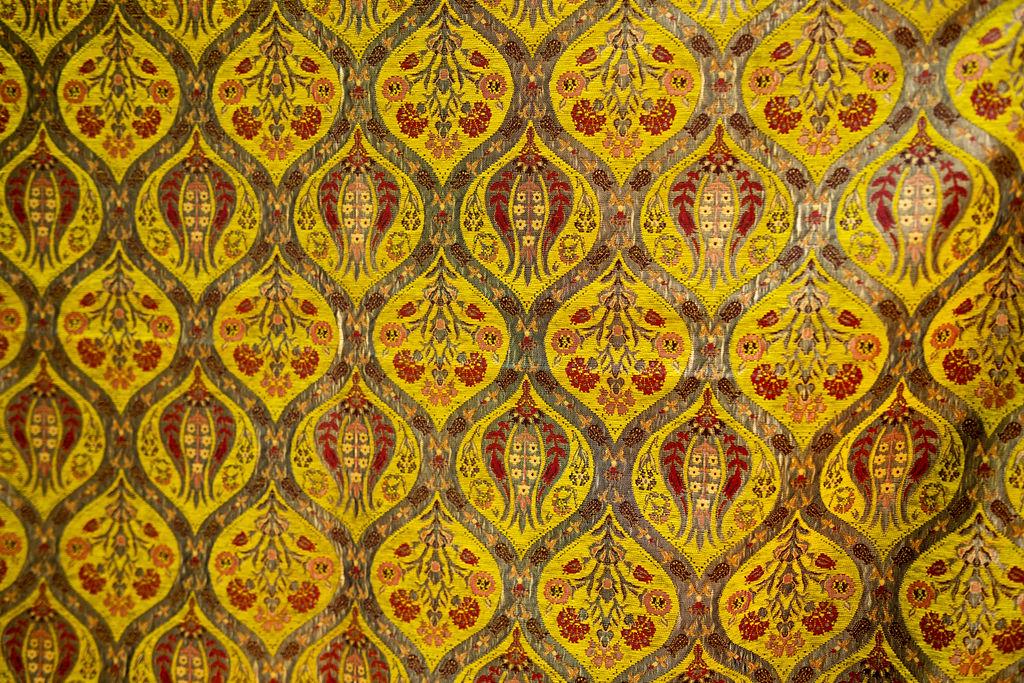 Close-up of yellow floral medallions with gray outlines and red accents