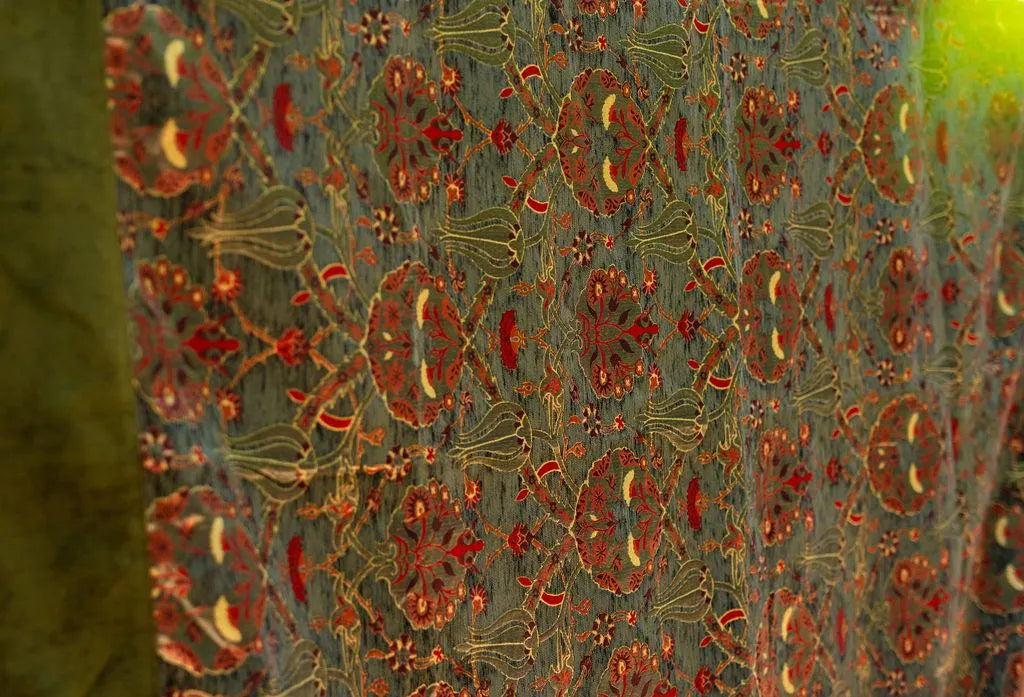 Angled detail of olive Turkish floral rug and plain green border
