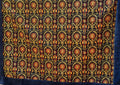 Square navy Turkish rug with repeating red and gold-tone floral motifs and broad blue border