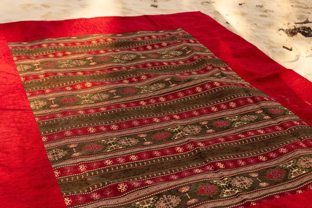 Overhead detail of geometric stripe patterns framed by the red rug border