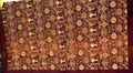 Burgundy Turkish rug with gold-tone framed motifs and a wide plain border
