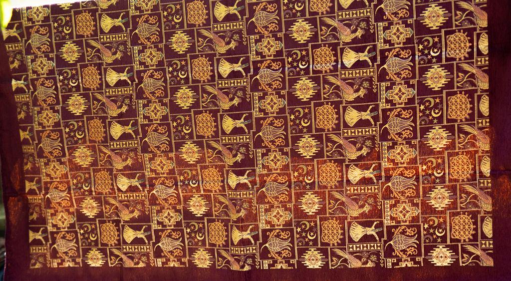 Burgundy Turkish rug with gold-tone framed motifs and a wide plain border