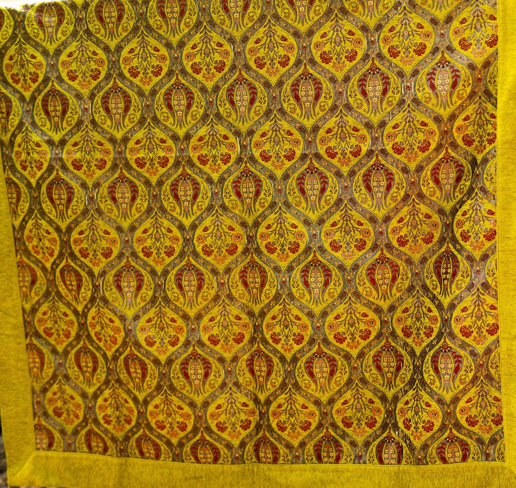 Yellow Turkish rug with repeating floral medallions and a wide plain yellow border